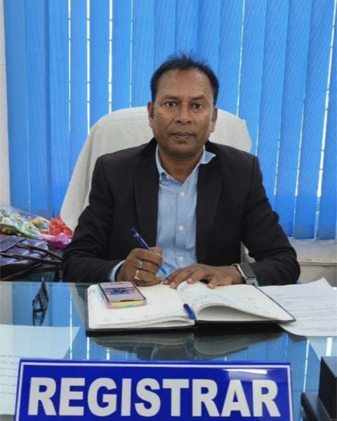 Portrait of Shri Maheswar Chandra Naik, Registrar, at the Registrar's desk.